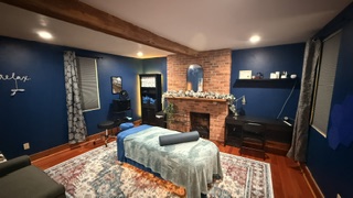 Blue-walled massage room with brick fireplace at the Delmont Tollhouse