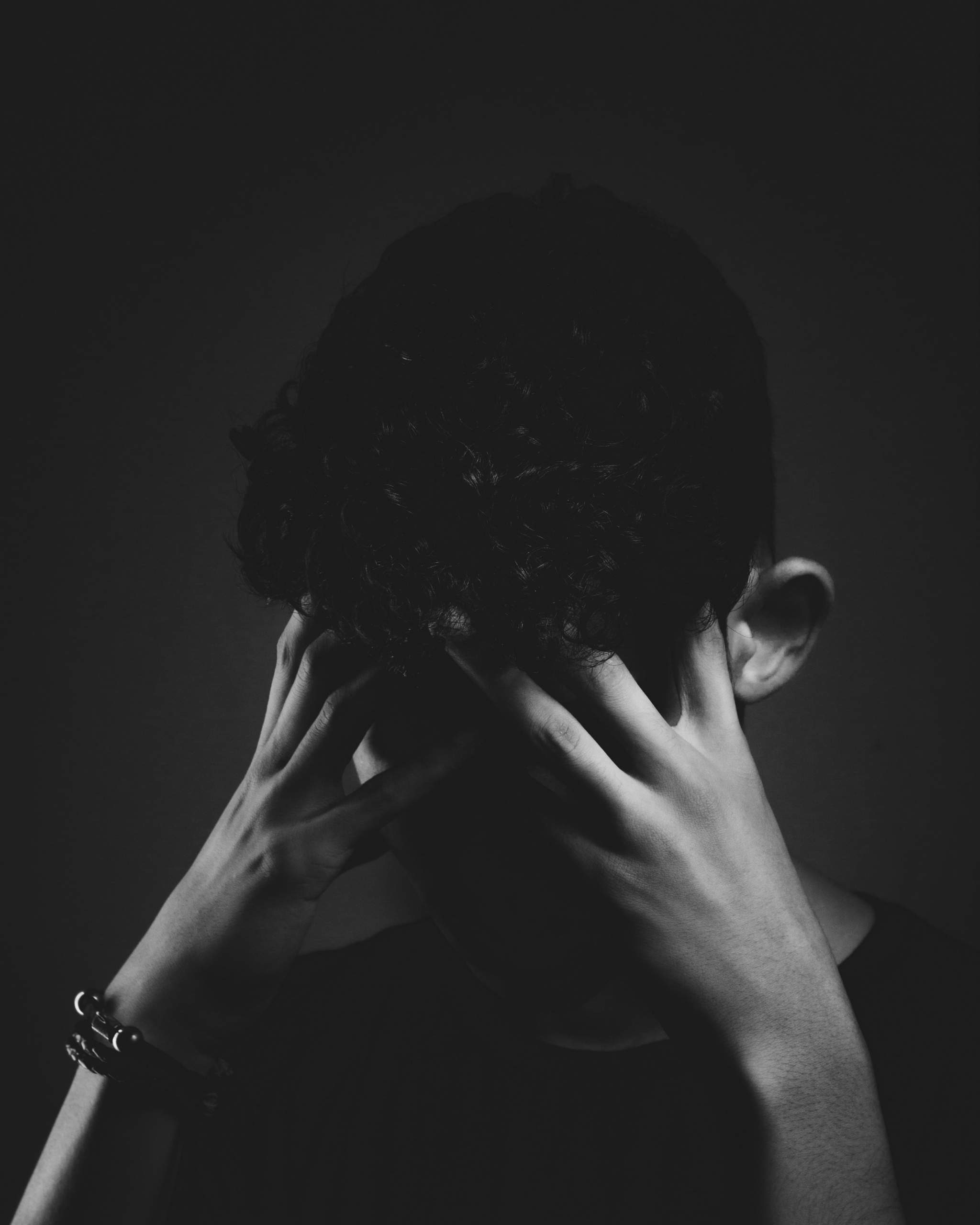 Person holding tight, tense muscles in the head and neck
